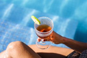 A person enjoys rum by the pool in Jamaica