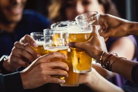 A group of people toast with beers at happy hour