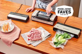 A side-by-side selection of vacuum sealers displayed on wood table with nearby meat and vegetables