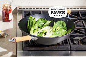 Wok filled with bokchoy in a gas stovetop