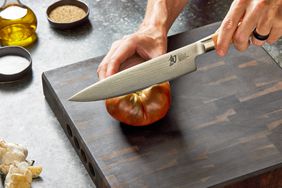 Slicing a tomato with Shun Classic Chef’s 8-Inch Knife on a wooden cutting board