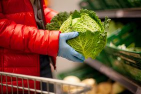 A person holds lettuce in the produce aisle