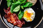 A poached egg with bacon, spinach and bread