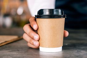 A to-go coffee cup being passed across the counter