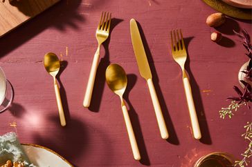Gold Flatware Set on a red table