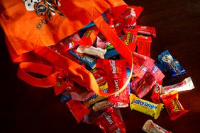 Various candies falling out of a halloween treat bag