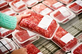 A person shops for ground beef in a grocery store