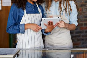 Two restaurant workers look over an iPad